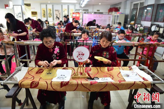 江西省級(jí)非遺豫章繡傳承人手把手指導(dǎo)小學(xué)生繡制2022年北京冬奧會(huì)吉祥物“冰墩墩”形象?！∮髟屏?攝