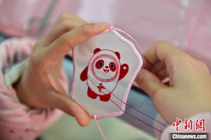 圖為一名小學(xué)生正在繡制2022年北京冬奧會(huì)吉祥物“冰墩墩”形象。　喻云亮 攝