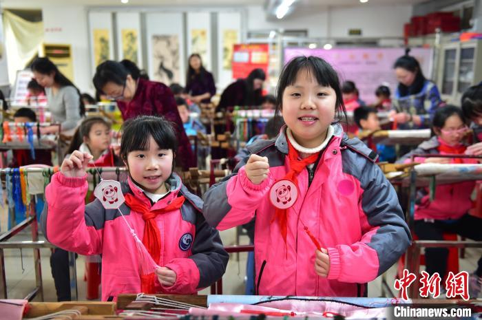 圖為小學(xué)生展示繡制好的2022年北京冬奧會(huì)吉祥物“冰墩墩”形象?！∮髟屏?攝