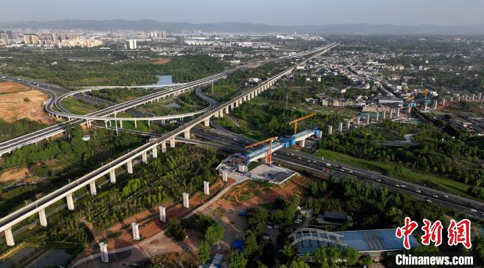 航拍正在建設(shè)的跨越成都繞城高速公路連續(xù)梁施工現(xiàn)場(chǎng)，旁邊依次為已運(yùn)營(yíng)的成渝高速鐵路和機(jī)場(chǎng)高速公路。　劉忠俊 攝