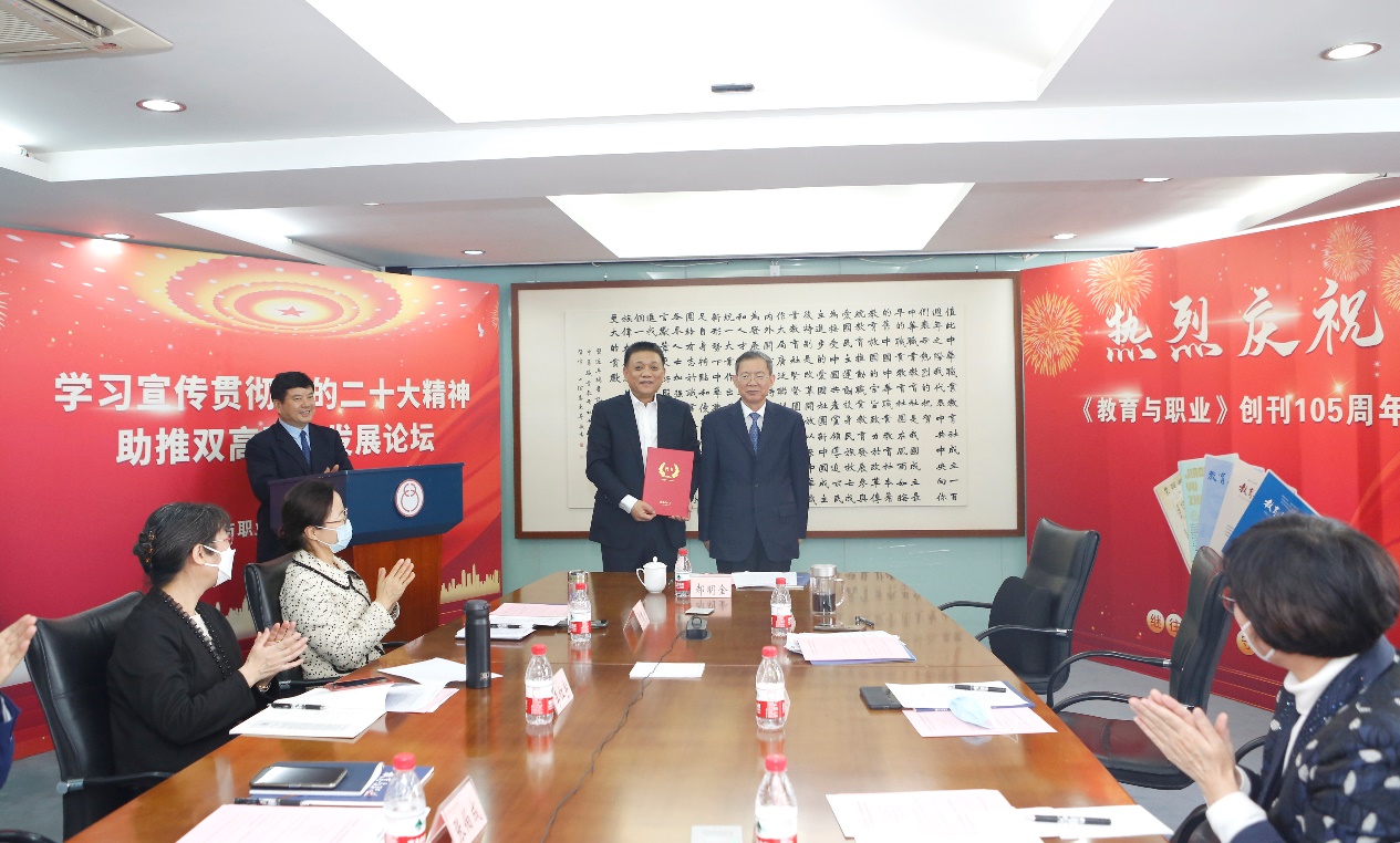 郝明金為《教育與職業(yè)》雜志編委代表陳曉明頒發(fā)聘書。中華職教社供圖