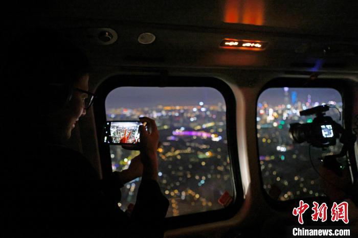 6月3日晚，游客乘坐上海新空直升機(jī)有限公司直升機(jī)開啟鳥瞰黃浦江空中圓夢之旅，并用手機(jī)拍攝城市夜景?！∫罅⑶?攝