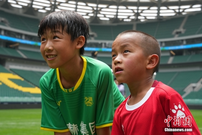 圖為北京國安小球員陳小北和7歲的俄金仁增在一起觀看場內(nèi)播放的紀錄片。<a target='_blank' href='/' _fcksavedurl='/'><p  align=
