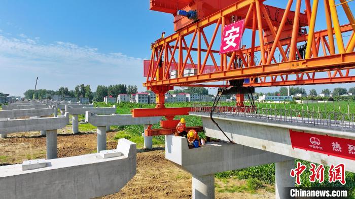 長25米重80噸的箱梁平穩(wěn)、精準地落在S314分離式立交橋25號和26號墩上?！⒂癫?攝