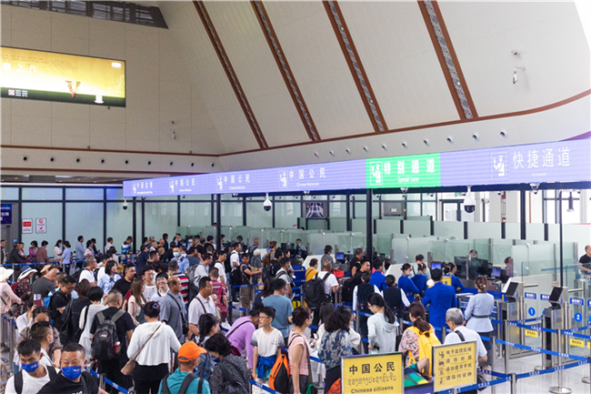 7月22日，乘坐中老鐵路國(guó)際旅客列車的旅客在磨憨邊檢大廳排隊(duì)候檢。衛(wèi)海林 攝
