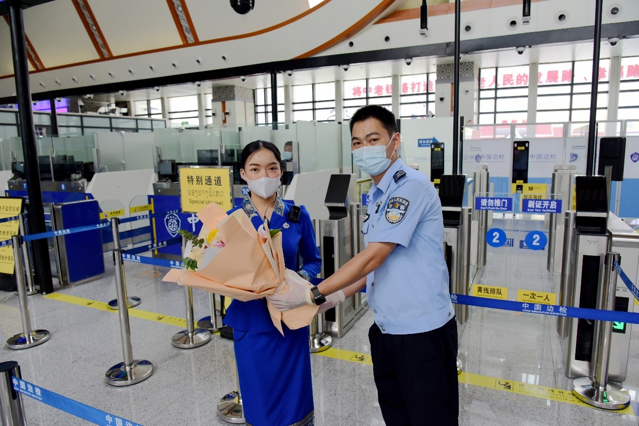 磨憨出入境邊防檢查站民警為中老鐵路第100萬名出入境旅客，D888次國際旅客列車老撾籍乘務員森達拉·妮緹婭（Sengdala Nitiya），送上鮮花。黃遠飛 攝