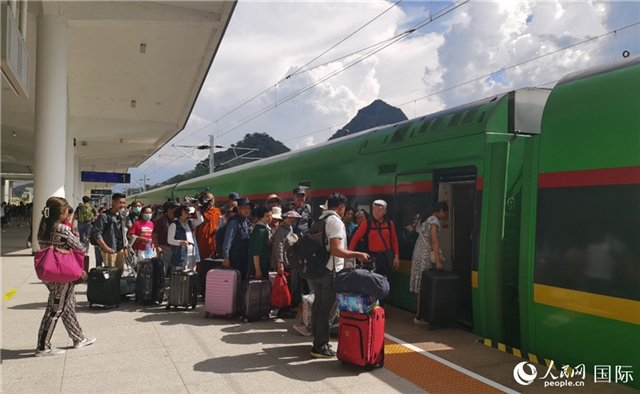 乘坐中老鐵路國際旅客列車的旅客在老撾瑯勃拉邦站排隊(duì)上車。人民網(wǎng)記者 杜明明攝