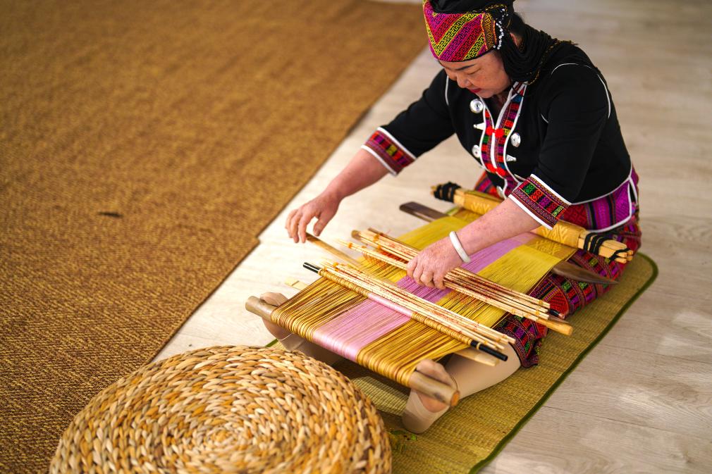 4月17日，黎族傳統(tǒng)紡染織繡技藝國家級代表性傳承人劉香蘭在2023年意大利米蘭設(shè)計周上展示黎錦織造技藝。新華社發(fā)