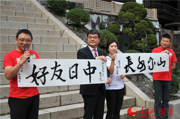 東京中國文化中心主任羅玉泉展示其為本次活動書寫的題詞“中日友好，山高水長”。人民網(wǎng) 蔣曉辰攝
