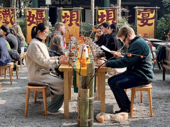 哥倫比亞大學青年學生代表團與蒲江縣鐵牛村村民一起交流、品嘗當地的小火鍋。