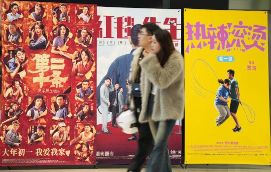 這是2月17日，在沈陽一家影院，觀眾從海報前經(jīng)過。新華社記者李鋼攝