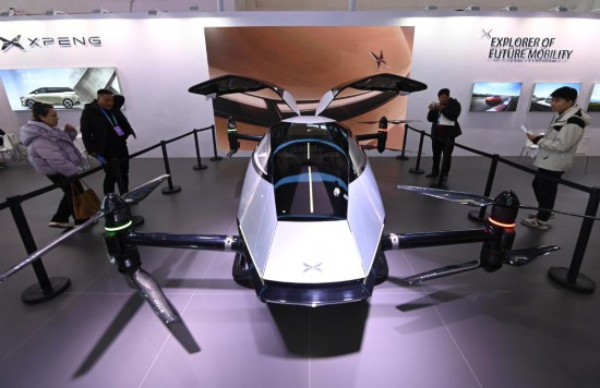 2023年12月1日，在鏈博會智能汽車鏈展區(qū)小鵬汽車展臺，參觀者觀看一臺智能飛行器。新華社記者蔡湘鑫攝