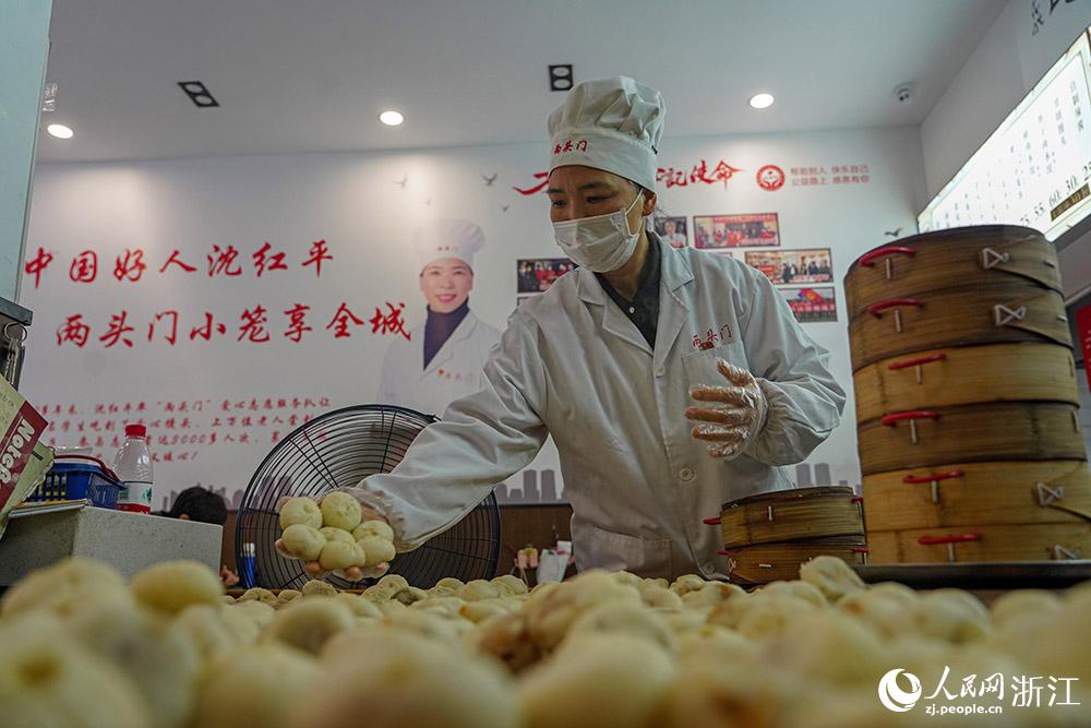 3月31日，在浙江省嵊州市甘霖鎮(zhèn)，嵊州小吃從業(yè)者沈紅平把蒸熟的小籠包晾涼，打包冷藏售賣。人民網(wǎng) 章勇濤攝