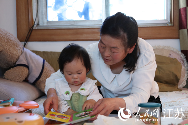 王繼蓮帶孫女看童書。人民網(wǎng) 冷金明攝