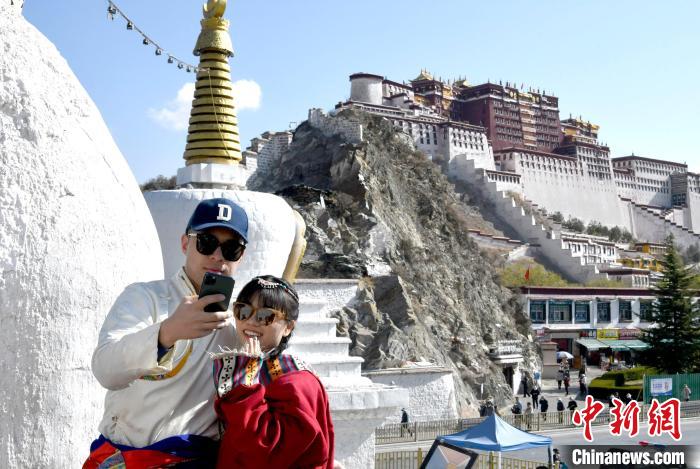 4月17日，游客身著藏式元素服裝在拉薩布達(dá)拉宮觀景臺(tái)拍照留念。　李林 攝