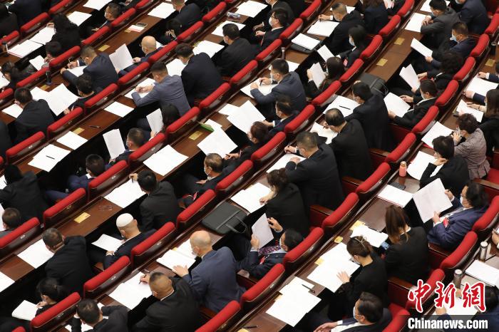 圖為會議現(xiàn)場，參會代表正在聽取政府工作報(bào)告?！∑钤鲚?攝
