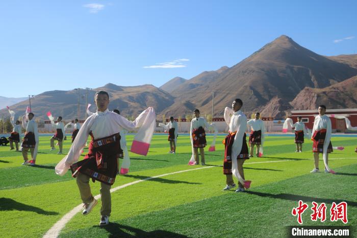 圖為青海師范大學(xué)附屬玉樹實驗學(xué)校學(xué)生在綠茵場跳起囊謙古舞—卓根瑪?！〕逃?攝