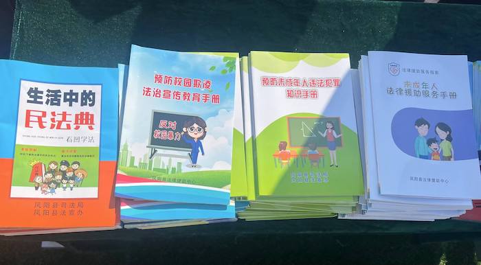 有關部門分發(fā)的普法宣傳冊。人民網 高清揚攝