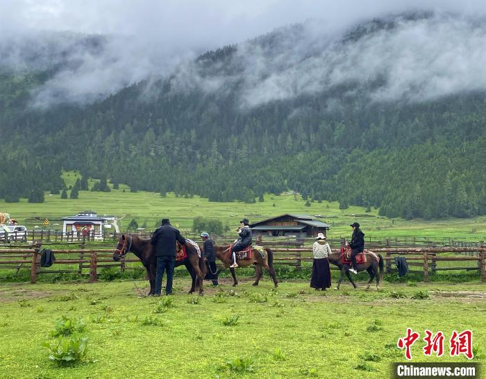 6月10日，游客在魯朗小鎮(zhèn)高山牧場景區(qū)體驗騎馬?！∪轿木?攝