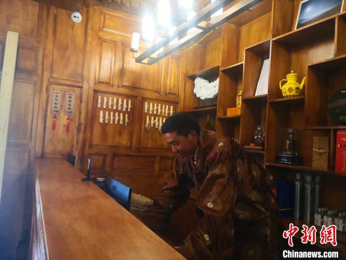 圖為桑杰才讓用電腦處理財(cái)務(wù)?！∈缝o靜 攝