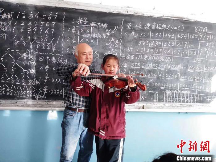 圖為趙興洲教學(xué)生拉小提琴。受訪者提供