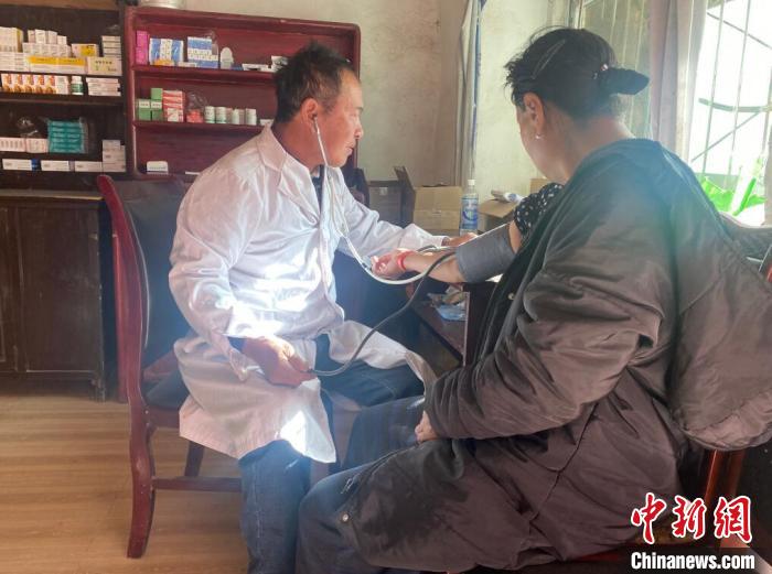 索木滾(左)為村民看病?！∪捞量h委宣傳部供圖