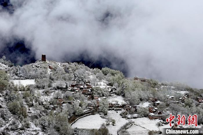 雪后的藏寨和碉樓構(gòu)成美麗的雪景?！〗党鯘衫?攝