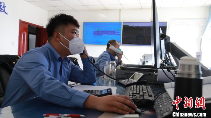圖為貨運調(diào)度人員與外勤工作人員聯(lián)系掌握車輛裝載情況?！±钌?攝