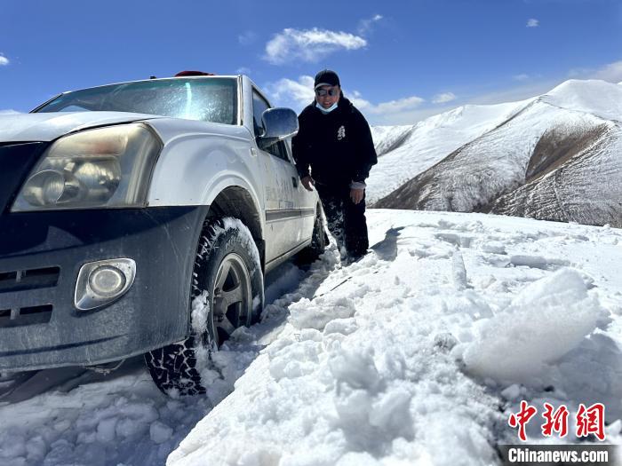 圖為生態(tài)管護人員準備在雪地推車?！《“瓦_杰 攝
