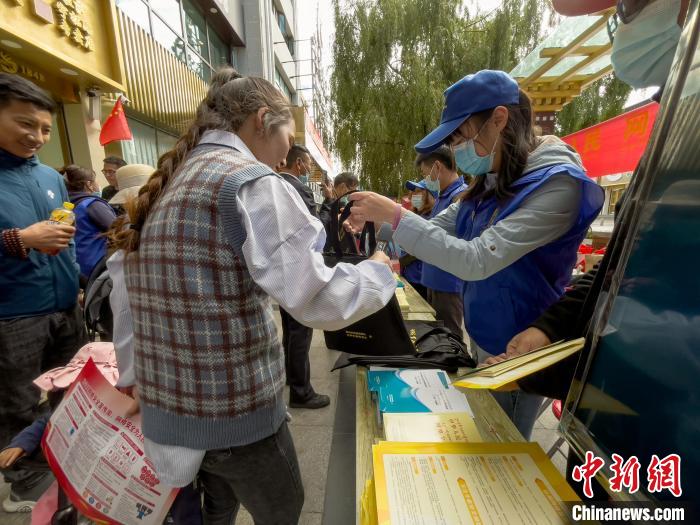 圖為志愿者為市民發(fā)放網(wǎng)絡(luò)安全宣傳手冊(cè)?！≈x牧 攝