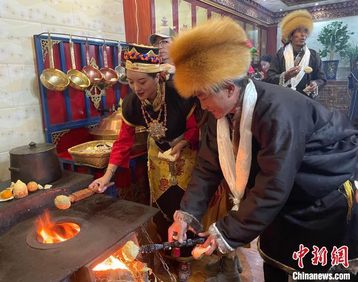 圖為人們在火上烤節(jié)日美食“結(jié)達”。　冉文娟 攝