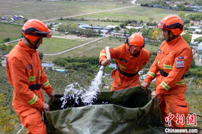 技能大練兵過程中，消防員在陡坡上向蓄水池注水?！±顕?guó)燾 攝