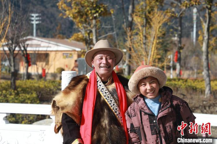 圖為林芝市巴宜區(qū)布久鄉(xiāng)仲果村村民桑杰與孫子一起參加藏歷新年活動。　張力 攝