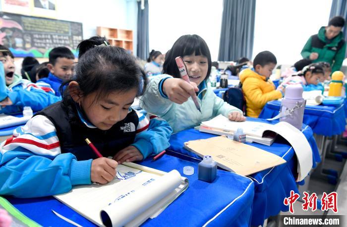 3月14日，西藏拉薩市第一小學一年級六班學生白瑪朗珍(圖左)在藏語文課上書寫藏文?！±盍?攝