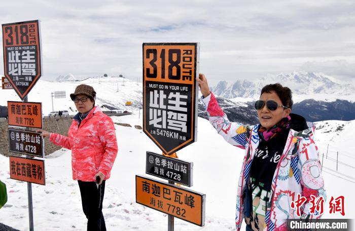 圖為5月14日，西藏林芝色季拉山觀景臺(tái)，游客與南迦巴瓦峰合影?！±盍?攝
